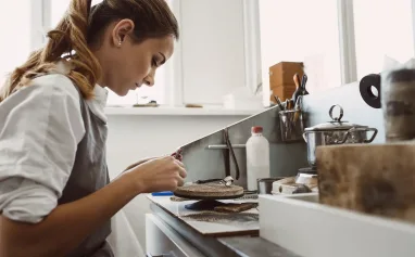 secret-technology-side-view-of-young-female-jeweler-working-on-a-new-silver-ring-at-her-workbench