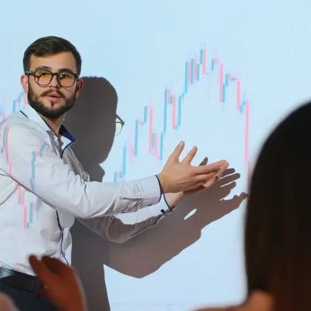 trading-teaching-male-leader-talking-to-employees-showing-the-plan-on-the-projector-in-office